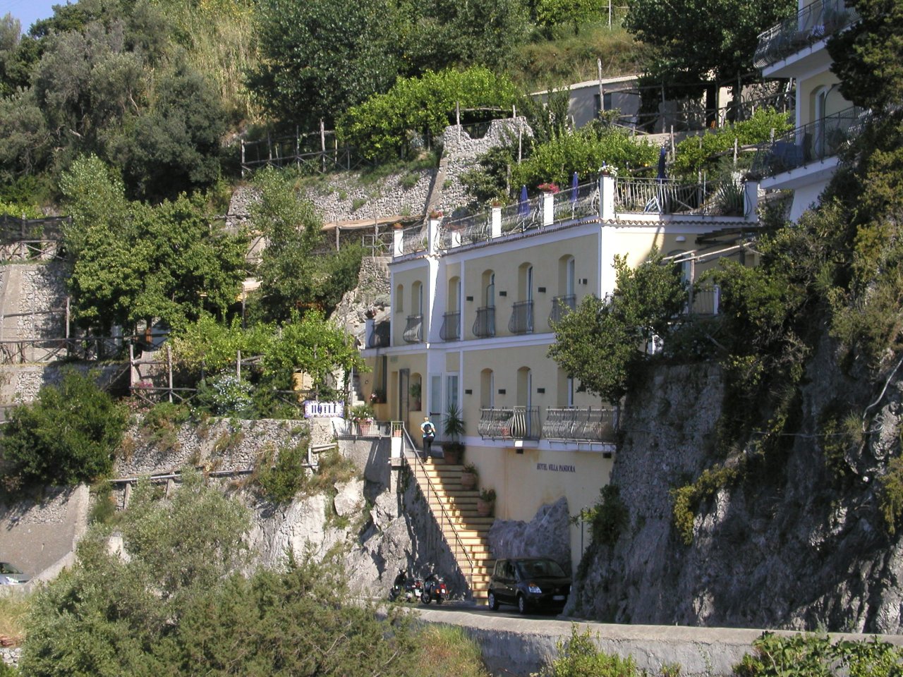JPEG image - Minerva : Like most hotels, this one is built onto / into the rock face. The little black thing at the foot of the stairs is the rental car we had: fortunately small! ...